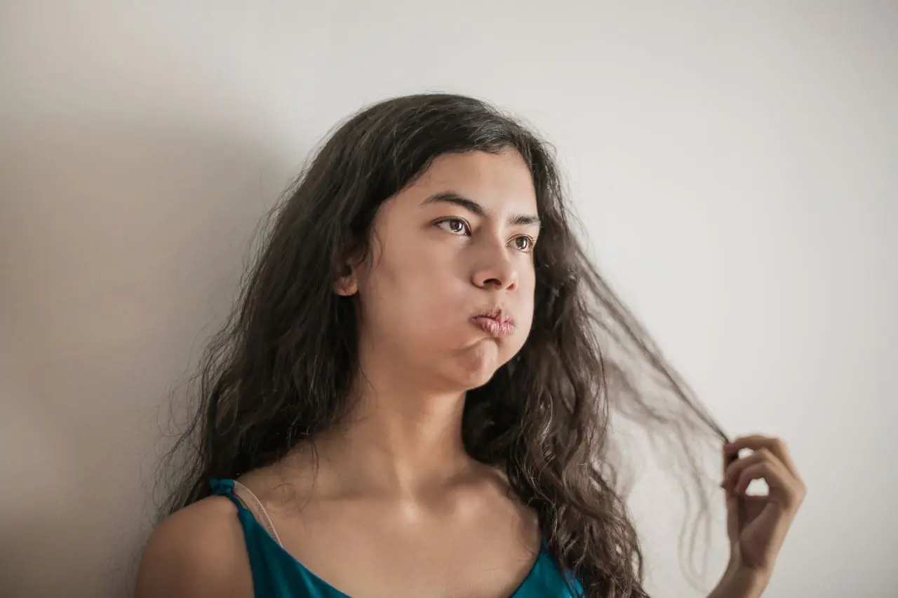 Tired woman dealing with frizzy hair
