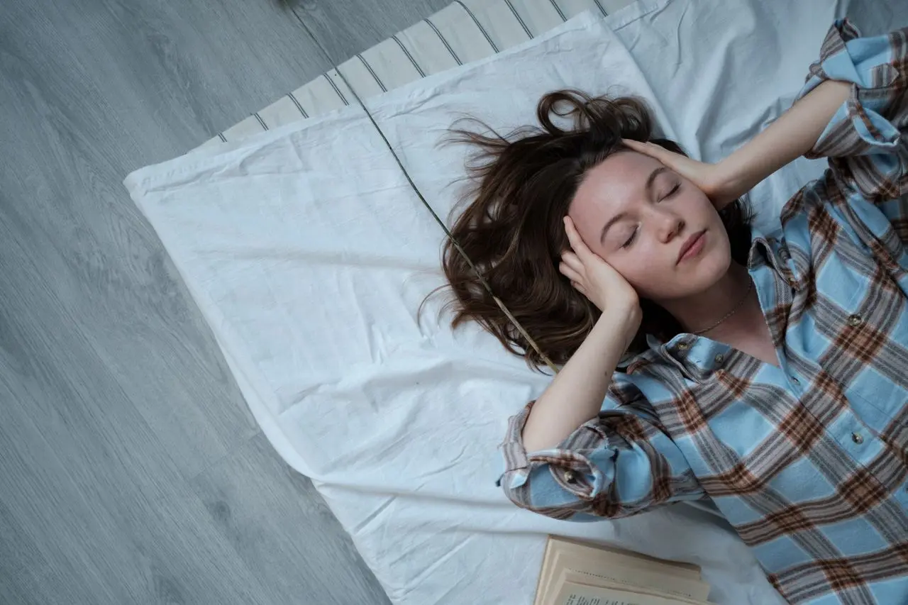 Woman with insomnia and a headache due to lack of sleep