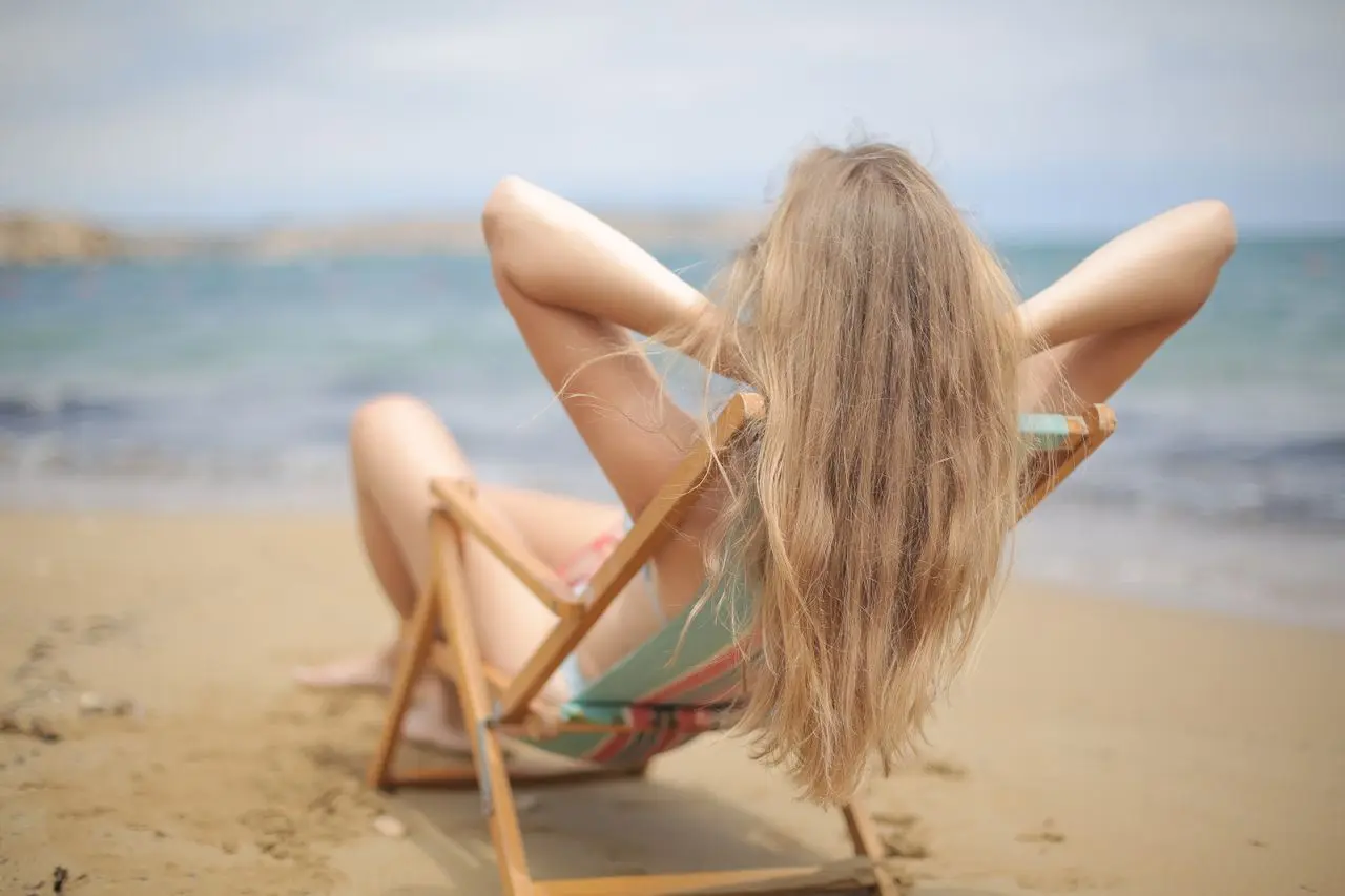Chica pelo rubio tomando el sol de espaldas