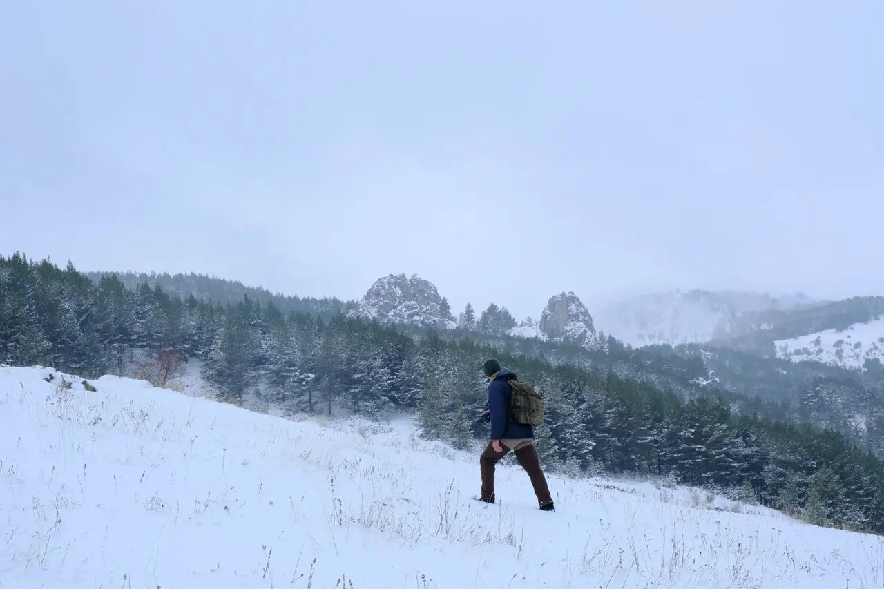 Hombre haciendo senderismo en una montaña con nieve