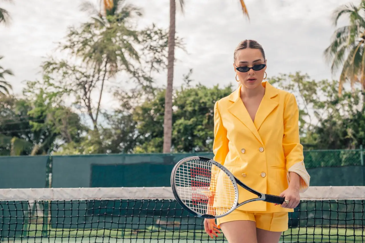 Chica en un entorno lujoso jugando a tenis