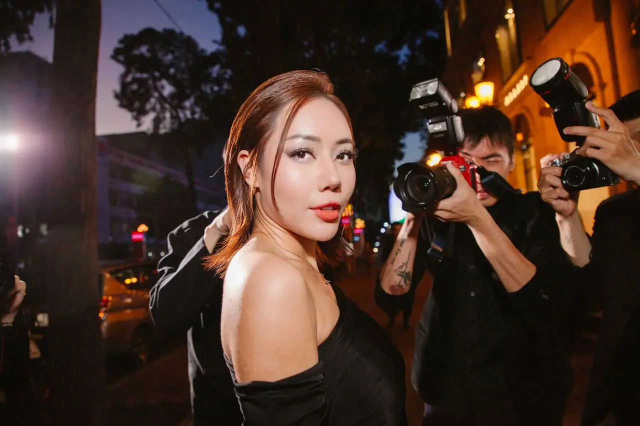 Chica rodeada de paparazzis haciéndole fotos